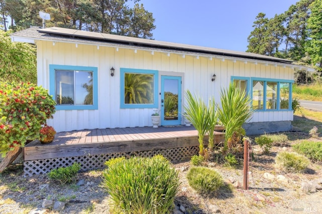 view of front of house featuring a wooden deck and solar panels