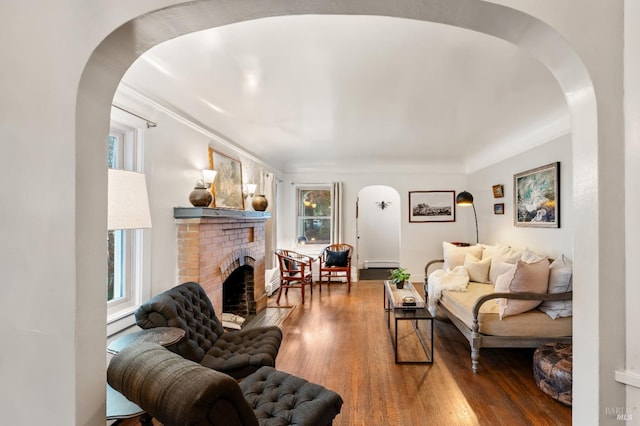 living room featuring a fireplace, hardwood / wood-style floors, and ornamental molding