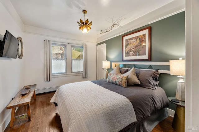 bedroom featuring hardwood / wood-style floors and baseboard heating