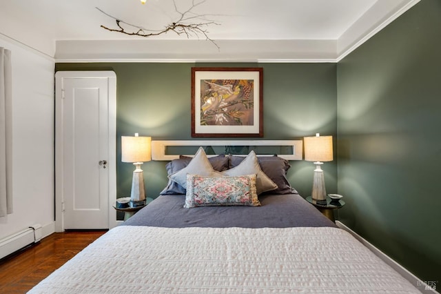 bedroom with wood-type flooring and a baseboard heating unit