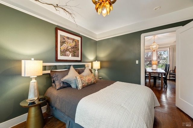 bedroom with dark hardwood / wood-style floors and ornamental molding