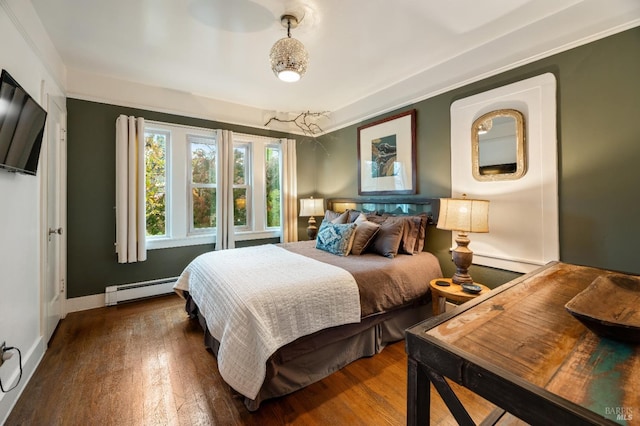 bedroom with a baseboard radiator and hardwood / wood-style flooring