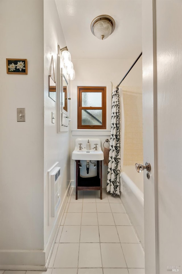 bathroom with tile patterned floors, sink, shower / tub combo, and heating unit