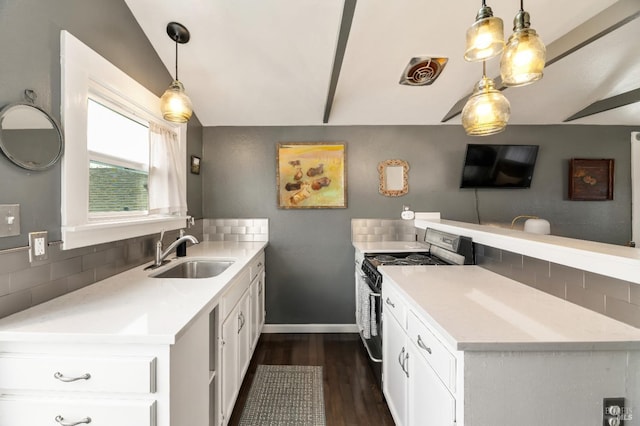 kitchen with tasteful backsplash, sink, white cabinets, and stainless steel gas range