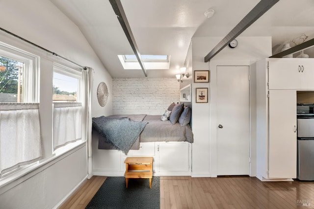 living area with lofted ceiling with skylight and light hardwood / wood-style flooring