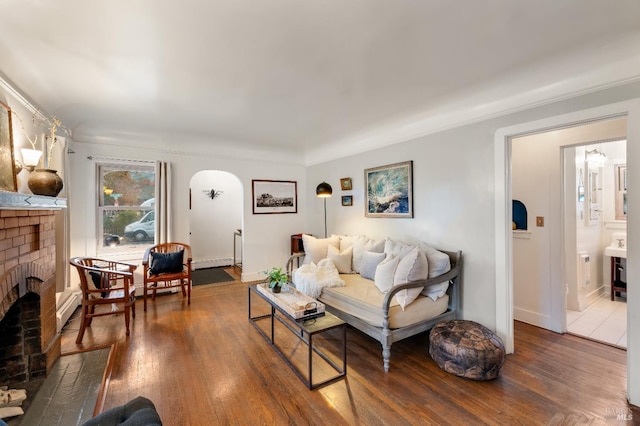 living room with dark hardwood / wood-style flooring and a brick fireplace