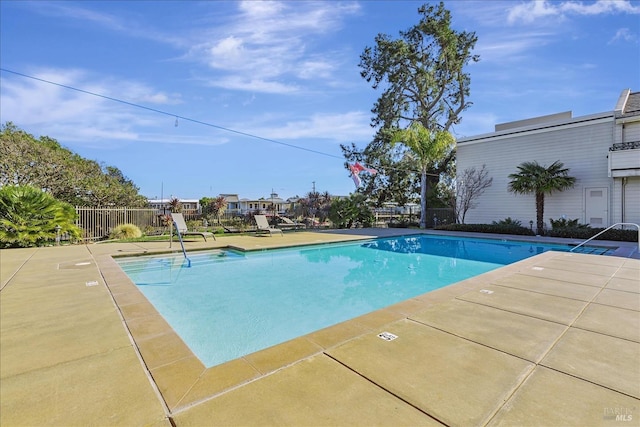 community pool featuring a patio area and fence