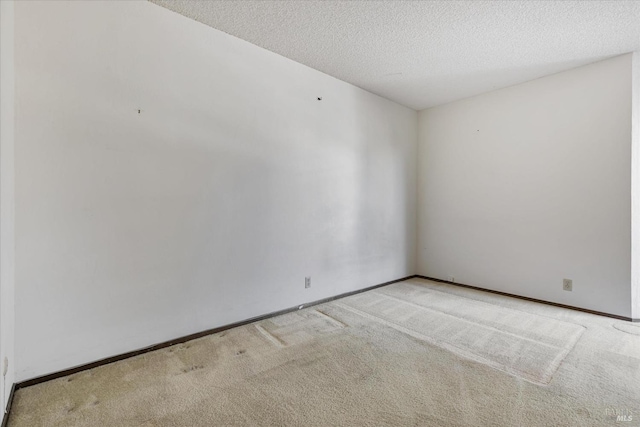 unfurnished room with light carpet and a textured ceiling