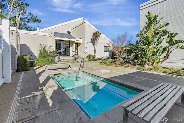 view of swimming pool featuring a patio area and a hot tub