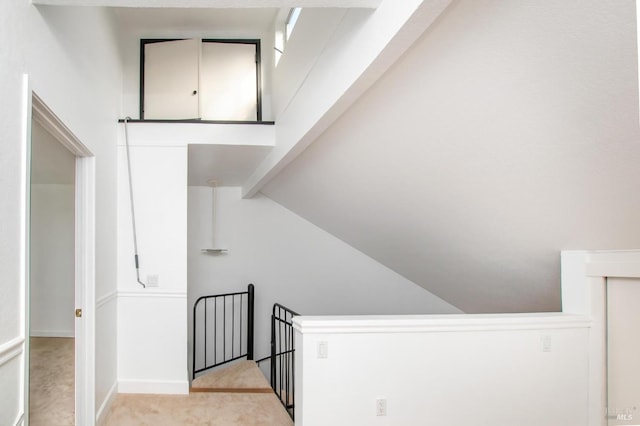 stairway featuring carpet flooring and vaulted ceiling with beams