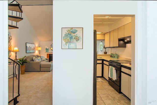 kitchen featuring light tile patterned flooring, white cabinets, and black range with electric stovetop