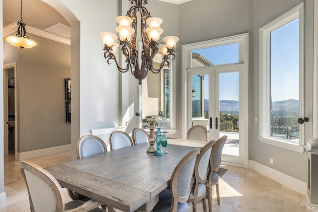 dining room with a mountain view, french doors, an inviting chandelier, and ornamental molding