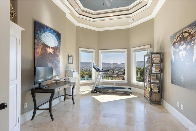 workout area with a high ceiling, a tray ceiling, ceiling fan, and ornamental molding