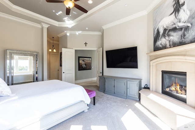 carpeted bedroom featuring ceiling fan with notable chandelier, a raised ceiling, and ornamental molding