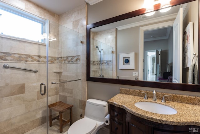 bathroom featuring vanity, toilet, a shower with shower door, and crown molding