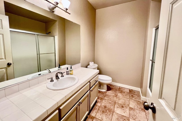 bathroom featuring vanity, toilet, and an enclosed shower