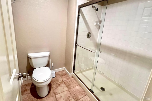 bathroom with toilet and a shower with door