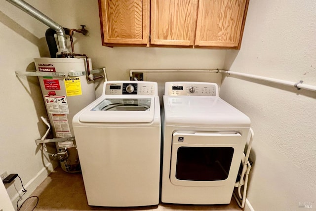 clothes washing area featuring separate washer and dryer, cabinets, and gas water heater