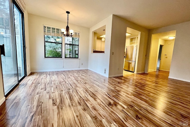 unfurnished dining area featuring hardwood / wood-style flooring and a notable chandelier