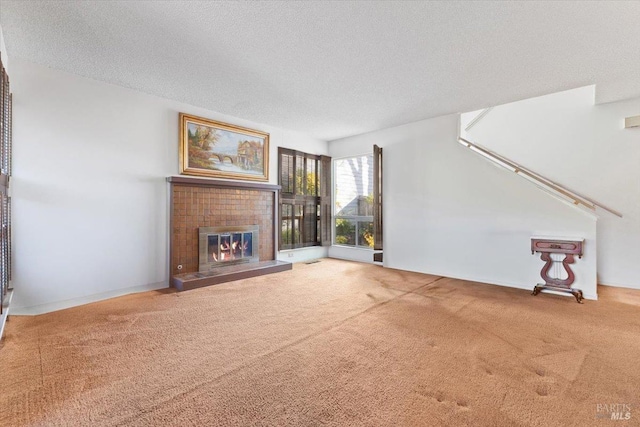 unfurnished living room featuring a textured ceiling, carpet floors, and a brick fireplace