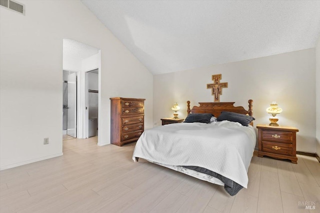 bedroom featuring light hardwood / wood-style floors and lofted ceiling