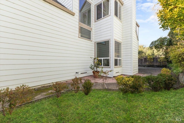 view of home's exterior with a lawn and a patio