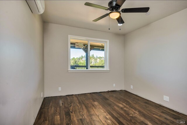 empty room featuring dark hardwood / wood-style floors, an AC wall unit, and ceiling fan