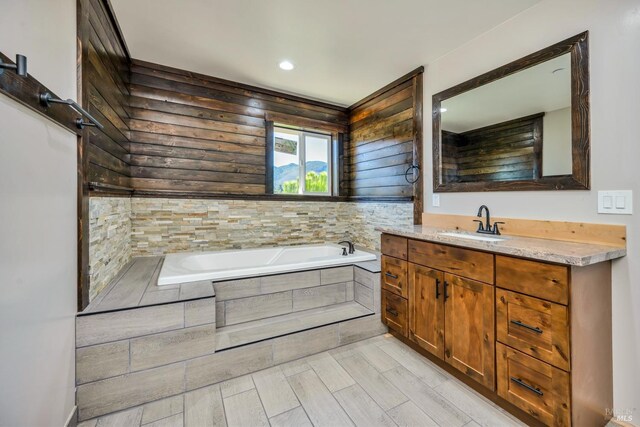 bathroom featuring tiled bath and vanity