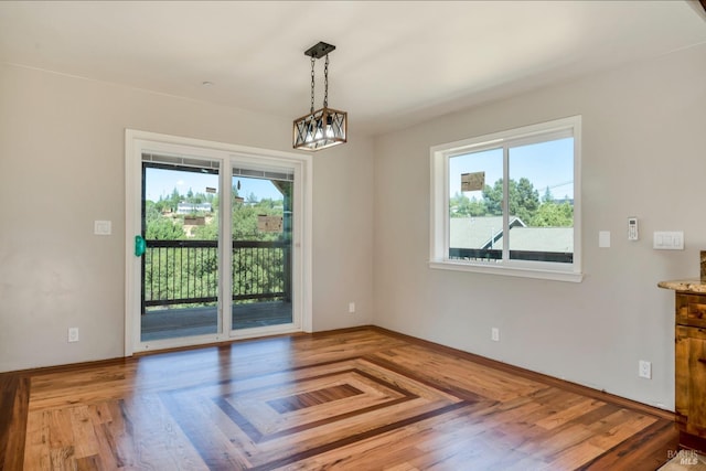 unfurnished dining area featuring hardwood / wood-style flooring and a notable chandelier