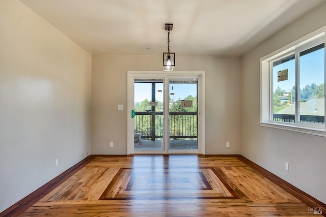 interior space featuring plenty of natural light, baseboards, and wood finished floors