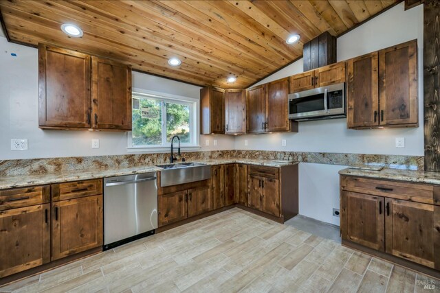 kitchen featuring light stone countertops, sink, light wood-type flooring, and stainless steel appliances