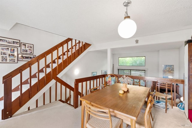 carpeted dining room with breakfast area and a textured ceiling