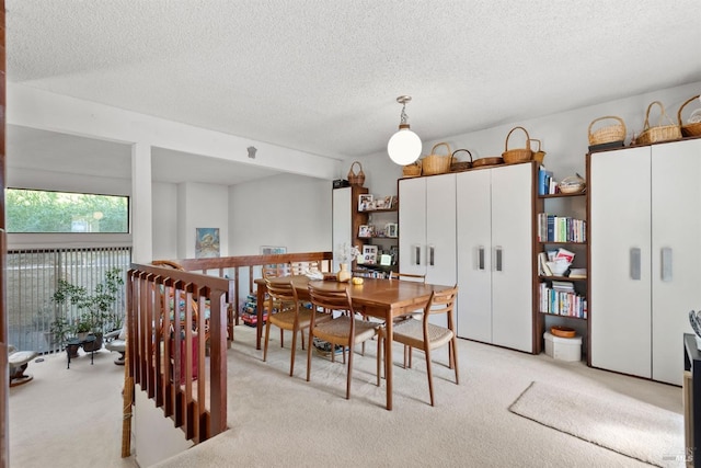 carpeted dining area featuring a textured ceiling