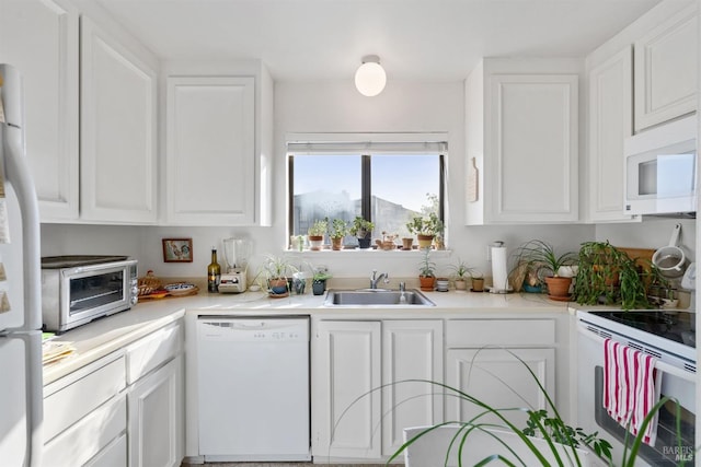 kitchen with sink, white cabinets, and white appliances