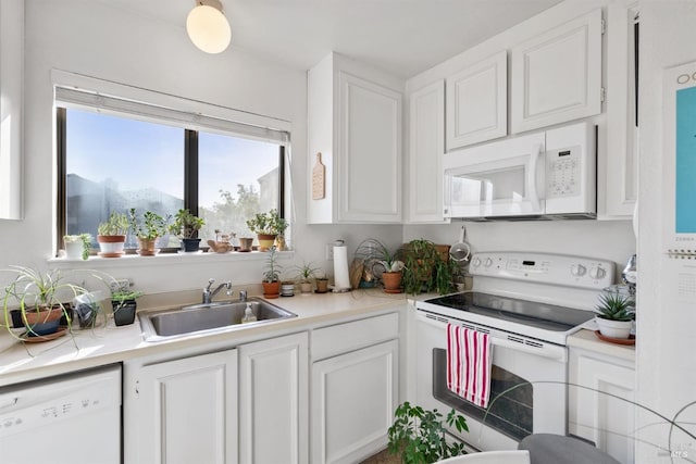 kitchen with a mountain view, white appliances, white cabinetry, and sink