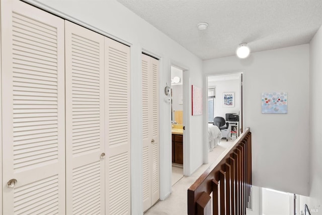 hall featuring a textured ceiling