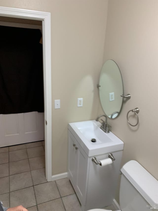 bathroom featuring tile patterned flooring, vanity, and toilet