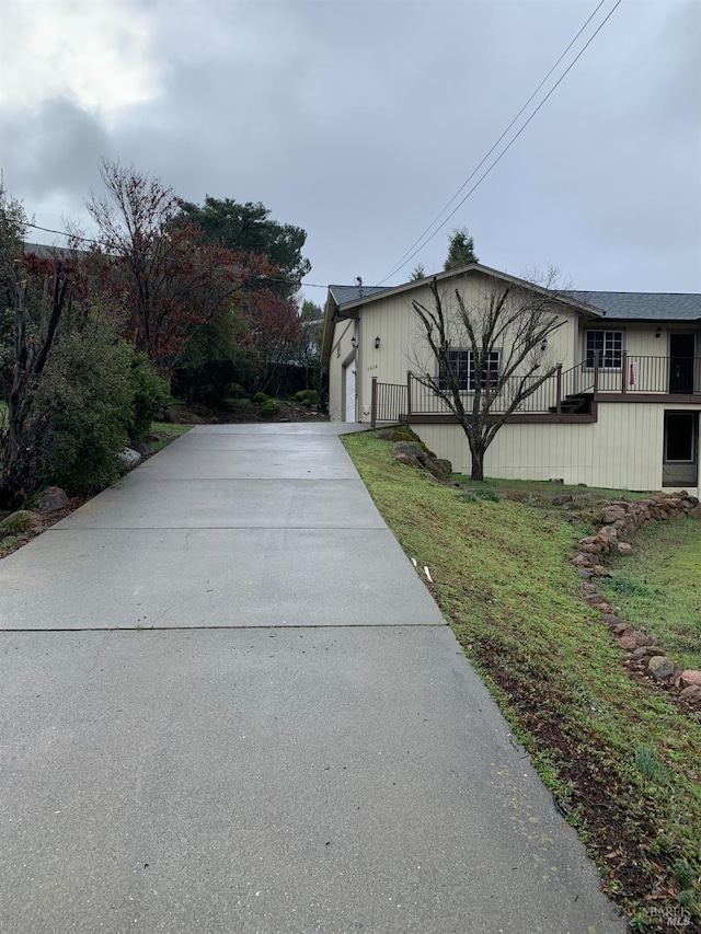 view of side of home with a garage and a lawn