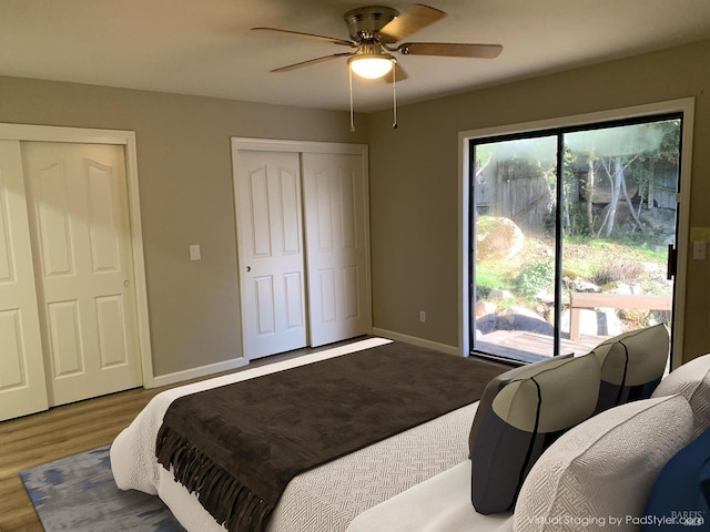 bedroom with multiple closets, ceiling fan, wood-type flooring, and access to outside