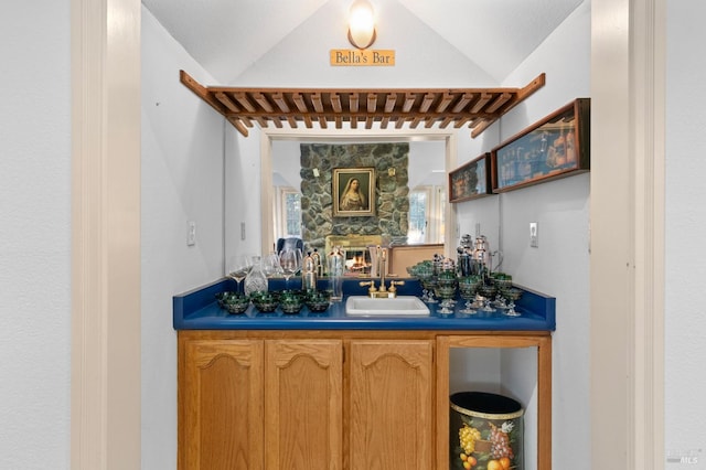 bar with lofted ceiling and sink