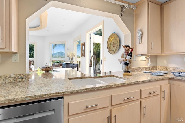 kitchen featuring dishwasher, light brown cabinetry, and sink