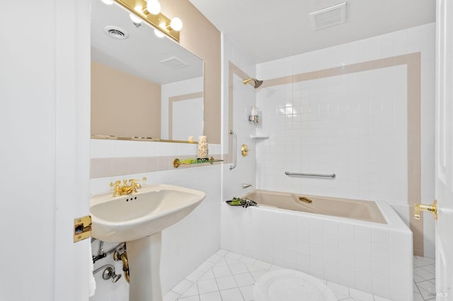 bathroom with tile patterned flooring, tiled shower / bath, and tile walls