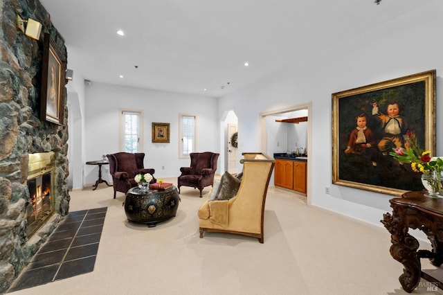 living room with a fireplace and light carpet