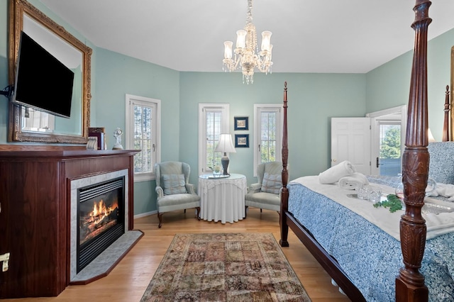 bedroom with light hardwood / wood-style floors and an inviting chandelier