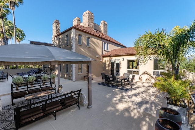 rear view of property featuring an outdoor living space and a patio area