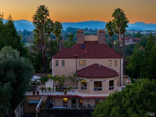 back house at dusk featuring a mountain view