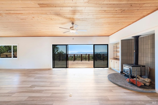 unfurnished living room with a wood stove, wooden ceiling, light hardwood / wood-style flooring, built in shelves, and ceiling fan