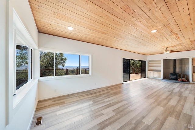 unfurnished living room with a wood stove, ceiling fan, wooden ceiling, and light wood-type flooring