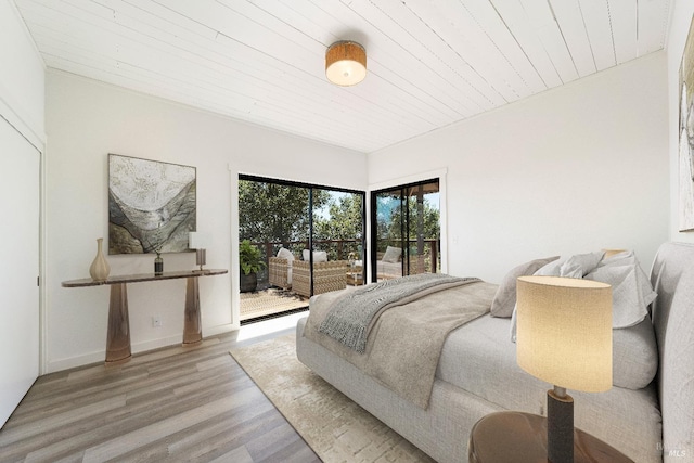 bedroom with light wood-type flooring, access to outside, and wooden ceiling