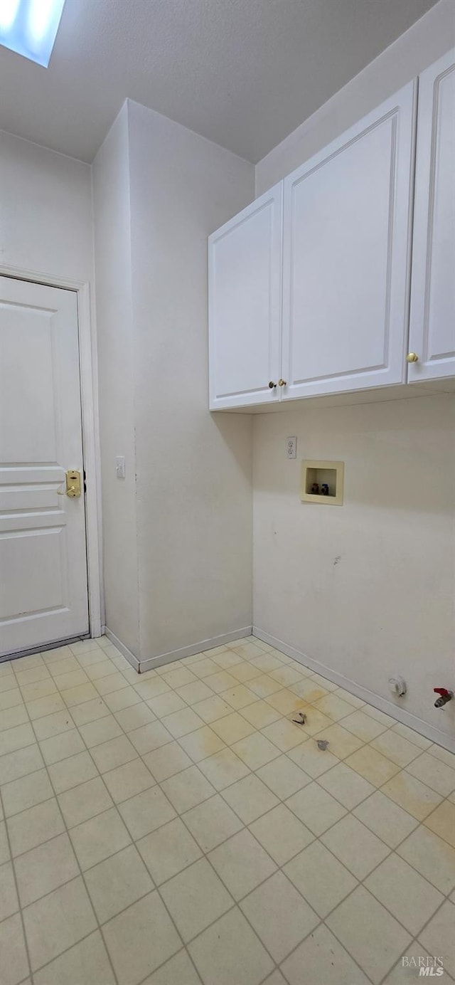 laundry room with hookup for a gas dryer, light tile patterned floors, cabinets, and washer hookup